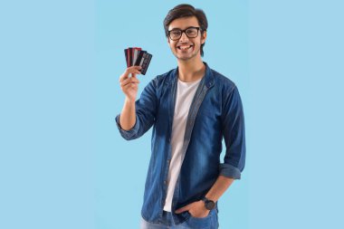 Genç bir adam kredi kartlarını gösteriyor..