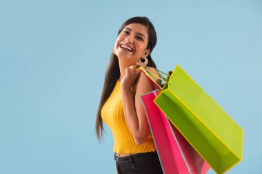 A young woman standing with Carrybags. clipart