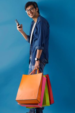 Cep telefonunu taşıyan genç bir adam..