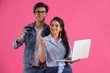 Çocuğun elindeki kartı gösteren dizüstü bilgisayarı olan bir kız..