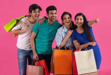 Bir kız, bir grup gencin arasında mutlu bir şekilde çantalarını taşırken başka bir yeri işaret ediyor..