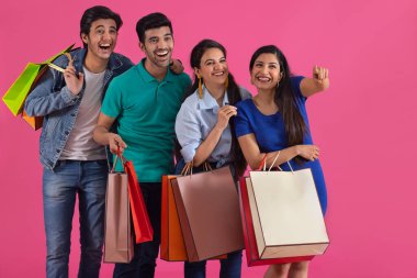 Bir kız, bir grup gencin arasında mutlu bir şekilde çantalarını taşırken başka bir yeri işaret ediyor..