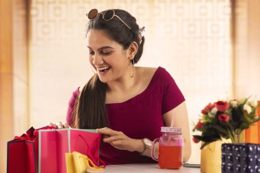 Çoklu çantasını gözetleyen mutlu bir kız..