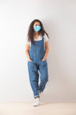 A TEENAGER WITH CURLY HAIR WEARING MASK AND LOOKING AWAY clipart