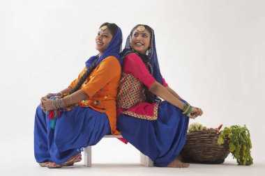 Arkasında sebze sepeti olan iki Giddha dansçısı..