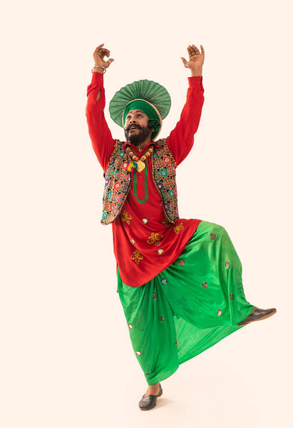 Танцовщица Бхангры, изображающая танцевальный шаг с поднятыми руками.