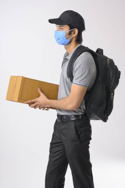 Elinde bir paketle gezen kurye çocuk yüz maskesi takarak teslim edilecek.