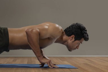 Adam arka planda şınav çekiyor.