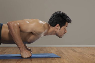 Adam arka planda şınav çekiyor.