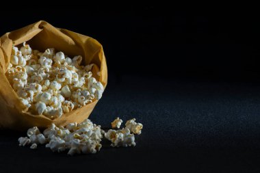 Kahverengi bir kese kağıdından düşmüş patlamış mısırlar..