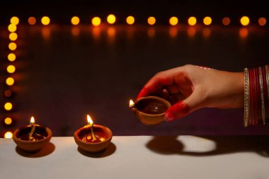 Diwali vesilesiyle parmaklıklara dizilmiş genç bir kadın..