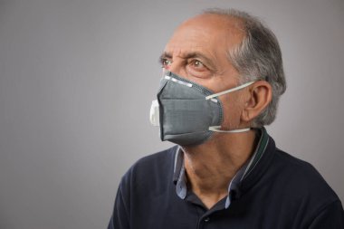 Kirlilik maskesi takan yaşlı bir adamın portresi. (Sağlık ve Spor)