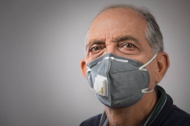 Kirlilik maskesi takan yaşlı bir adamın portresi. (Sağlık ve Spor)