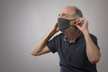 Kirlilik maskesi takan yaşlı bir adamın portresi. (Sağlık ve Spor)