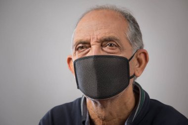Kirlilik maskesi takan yaşlı bir adamın portresi. (Sağlık ve Spor)