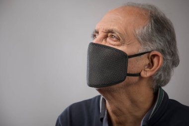 Kirlilik maskesi takan yaşlı bir adamın portresi. (Sağlık ve Spor)