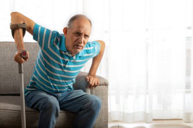 Kıdemli adam bastonla koltuktan kalkmaya çalışıyor, Cane. (Sağlık ve zindelik)