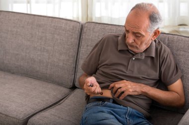 Kıdemli adam kendi kendine insülin iğnesi oluyor. (Sağlık ve zindelik)