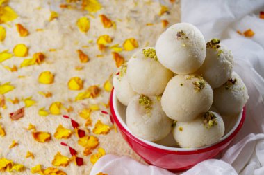 Ağız sulandıran beyaz rasgullalar bir kasede serpilmiş şam fıstıklarıyla saklanır..