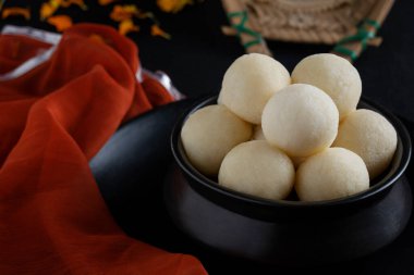 Close up of delicious white rasgullas kept in a black bowl. clipart