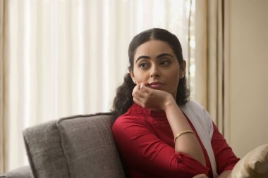 Evdeki düşüncelerinde kaybolmuş bekar bir kadının portresi..