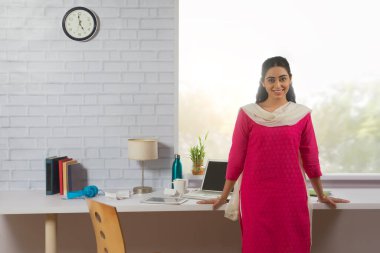 Portrait of a single woman standing in her office. clipart