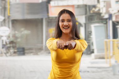 Sokakta kameraya gülümseyen güzel bir genç kadın.