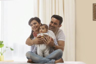 Family smiling together in living room clipart