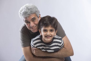 Büyükbaba torununa sarılıyor.