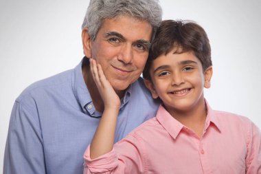 Büyükbaba ve torunun birlikte oturduğu portre.