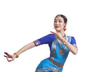 Genç bir kadın beyaz arka planda Hint Bharat Natyam dansı yapıyor.