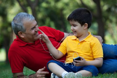 Grandson touching his grandfathers nose clipart