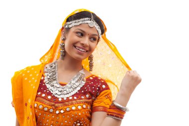 Beyaz arka planda choli ve dupatta giyen mutlu genç bir kadın.