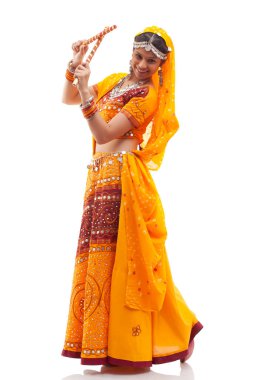 Chaniya Choli 'de beyaz arka planda Dandiya Raas' ı canlandıran mutlu genç bir kadının portresi.