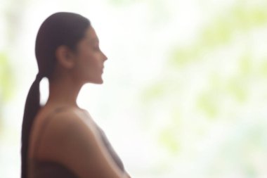 Meditasyon yapan genç bir kadının yan görünüşü