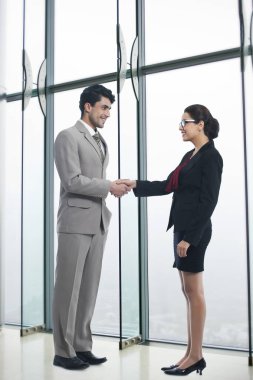 Portrait of smiling business colleagues standing arms crosses in office clipart