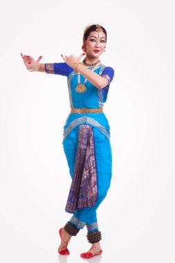 Güzel bir kadının beyaz arka planda Bharatanatyam 'ı seslendirdiği uzun bir portre.