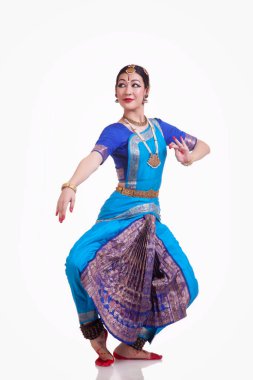 Beyaz arka planda Bharatanatyam 'ı seslendiren tam boy genç kadın.