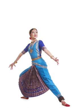 Geleneksel giyinmiş tam boy dansçı beyaz arka plana karşı Bharatanatyam icra ediyor