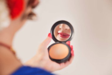 Beyaz arka planda el aynasına bakan Bharatanatyam dansçısı