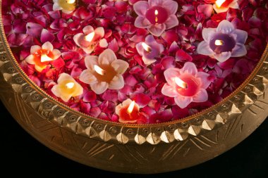 Close-up of an urn with floating diyas clipart