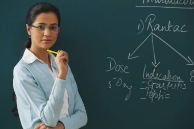 Yeşil tahtaya karşı kendinden emin genç öğretmenin portresi