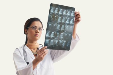 Genç bayan doktor ultrason raporunu analiz ediyor. Beyaz arka planda izole edilmiş.