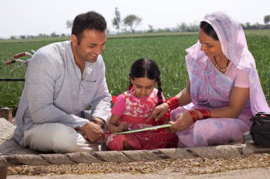 Baba ve anne, kızına ev ödevinde yardım ediyor.