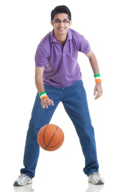 Beyaz arka planda basketbol oynayan genç adamın tam boy portresi