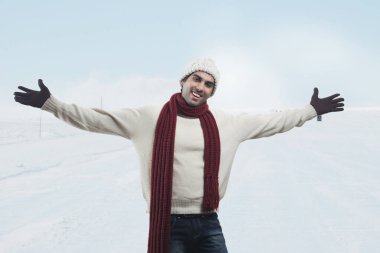 Kollarını açmış gülümseyen bir adamın portresi.