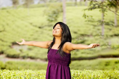 Çay tarlasında dikilmekten zevk alan bir kadın