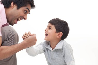 Heyecanlı baba beyaz arka plan için oğluyla bilek güreşi yapıyor.