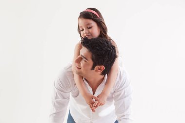 Kız babasının sırtında oturuyor.