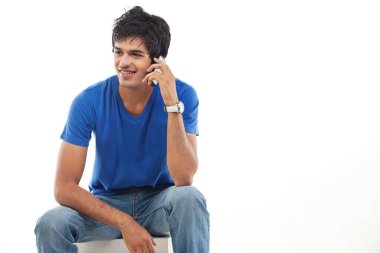 Genç adam beyaz arka planda telefon kullanıyor.